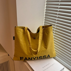 Minimalist large mustard yellow nylon tote bag with printed letters and metal buckle
