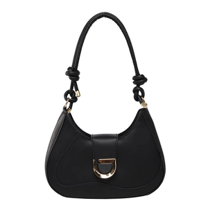 Chic black hobo bag with golden D-clasp and knotted shoulder strap detail on white background