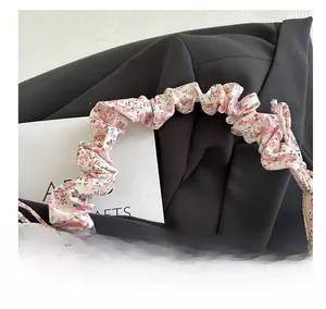 Détail de la bandoulière plissée à imprimé floral sur un sac nuage élégant