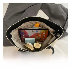 Vue de dessus d'un grand sac cabas en toile montrant les compartiments et un iPad