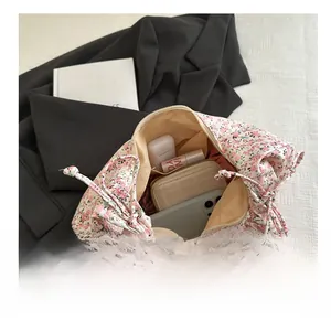 Détails du compartiment interne du sac floral contenant téléphone, portefeuille et rouge