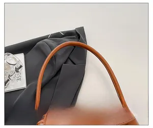Detail of the comfortable caramel leather shoulder strap on a retro baguette bag