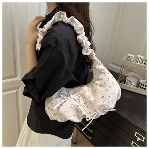 Détail du sac à fleurs avec bandoulière plissée nuage et nœud décoratif sur le côté