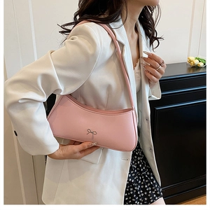 Detailansicht der rosa Halbmond-Tasche mit silberner Schleife, getragen von einem Model