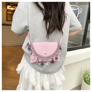 Detailed shot of pink woven saddle bag with ethnic embroidery and colorful tassels