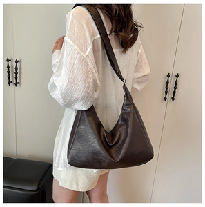 Detail of soft brown faux leather shoulder bag on model with wide strap and large capacity