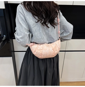 Detail of pink half-moon bag with butterfly embroidery and decorative knot strap