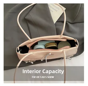 Internal capacity of light pink handbag with silver bow detail showing large main compartment