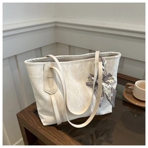 Detail of cream tote bag with pleated texture and decorative fashion print silk scarf