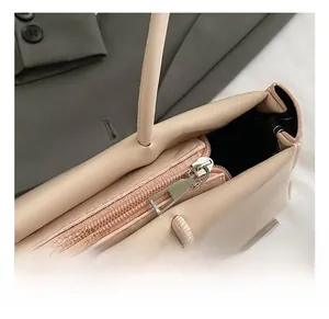 Detail view of pink ballet-style baguette bag showing silver zipper and ribbon bow accents