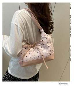 Detail of pink quilted bucket bag with bow print and drawstring bow decoration