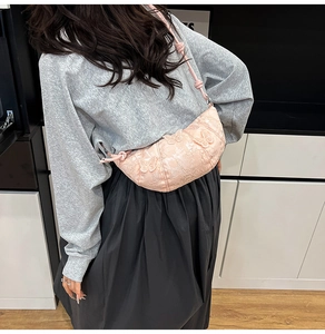 Detail of pink half-moon bag featuring 3D butterfly embroidery and lace texture