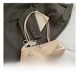 Detail of pink faux leather bag with silver bows and pearl lace strap trim
