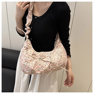 Sac à bandoulière floral avec nœud et bandoulière froncée porté par un mannequin