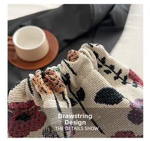 Detail of the drawstring closure on a floral jacquard bucket bag with woven texture