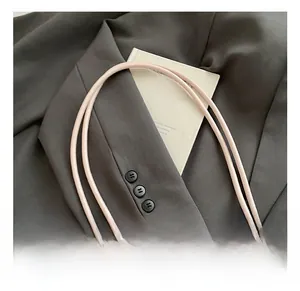 Close-up of a pink leather handbag handle with a minimalist chic Korean style aesthetic