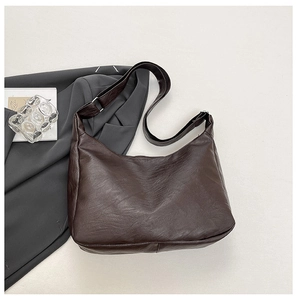 Detail of dark coffee vintage leather hobo bag with adjustable strap for office use