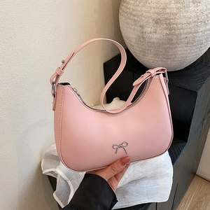 Pink minimalist crescent hobo bag with a silver metallic bow and adjustable strap