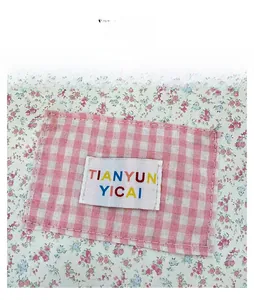 Détail de l'étiquette de marque tissée et de la texture du tissu fleuri du sac
