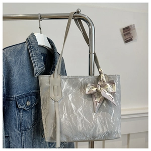 Detail of silver pleated tote bag with fashion print scarf handle and metallic texture