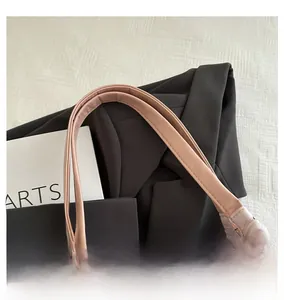 Close-up of pink quilted tote bag showing leather handles and black bow pattern details