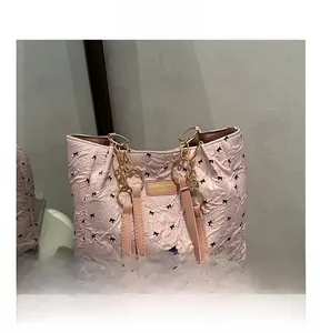 Sac fourre-tout rose avec imprimé nœuds noirs, texture matelassée et chaîne dorée