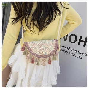 Detail of bohemian straw crossbody bag with colorful fringe and embroidery for summer