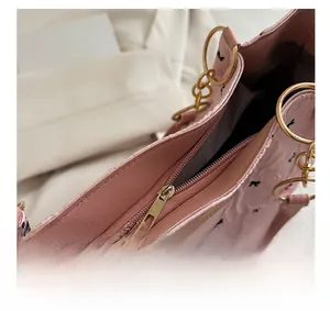 Détail de la fermeture éclair fluide et chaîne dorée sur ce sac cabas en cuir rose