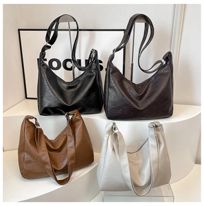 Detail of four retro PU leather hobo bags in assorted colors on a minimalist display