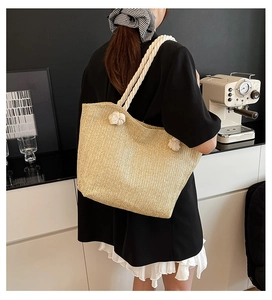Detailed texture of khaki straw tote bag with chunky white cotton rope shoulder straps