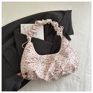 Vue détaillée du sac floral avec nœuds décoratifs et bandoulière à volants élégante