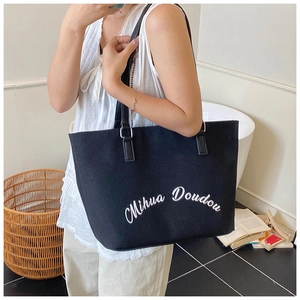 Vue détaillée de la broderie Mihua Doudou sur le grand sac cabas en toile noire