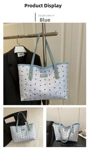 Detail der blauen Tragetasche mit Falten-Design und schwarzem Schmetterlingsdruck