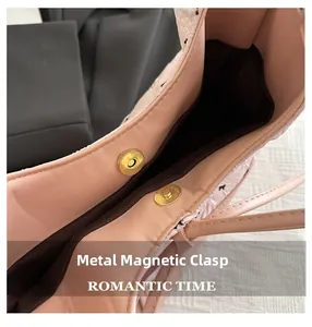 Close-up of golden magnetic snap closure on a pink leather tote bag with dark lining