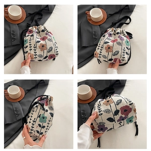 Detail of floral embroidered drawstring shoulder bag with colorful woven patterns
