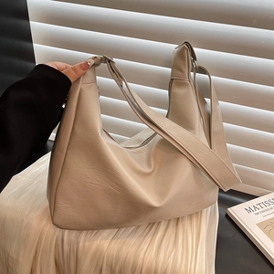 Minimalist beige PU leather tote bag with adjustable strap and textured finish for daily use