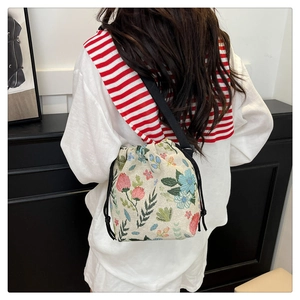 Detail of floral strawberry embroidery on beige jacquard drawstring bucket bag