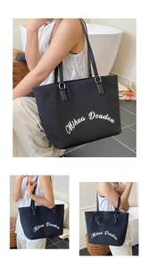 Détail du grand sac cabas noir en toile avec imprimé lettres et bandoulières en cuir