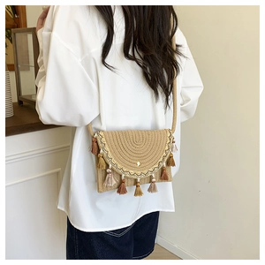 Detail of bohemian straw saddle bag with multi-colored long tassels and sequins
