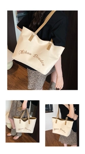 Détail d'un grand sac cabas en toile beige avec anses brunes et lettrage Mihua Doudou