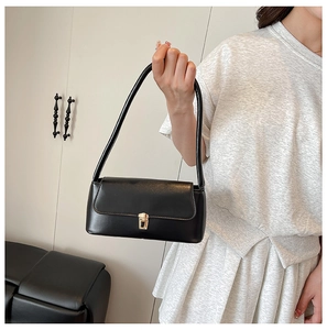 Classic black leather baguette bag featuring elegant gold metal clasp and sleek shoulder strap