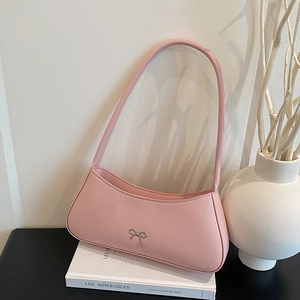 Pink French baguette bag with silver bow accent on Les Misérables books