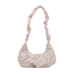Sac à bandoulière rose fleuri avec anse froncée et nœuds décoratifs sur fond blanc