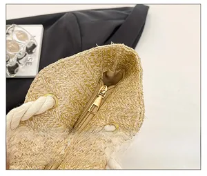 Detailed close-up of straw tote bag with smooth gold zipper and rope handles