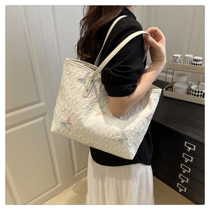 Detailed embroidery of colorful butterflies on a white quilted large capacity tote bag