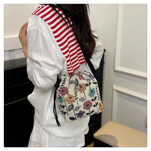 Ethnic bucket bag detail showing vintage floral embroidery and black drawstring closure