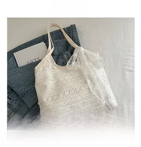 Close-up of white lace tote bag with floral cutout patterns and delicate side ruffles