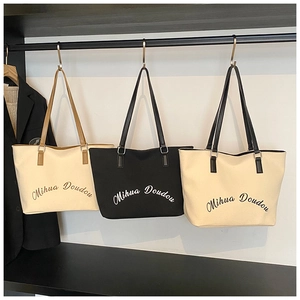 Detailed display of canvas tote bags in beige and black with stylish logo printing