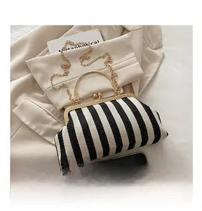 Detail of striped retro handbag with gold metal frame, ball clasp and chain strap