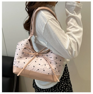 Dettaglio della borsa rosa a pieghe con motivi a fiocco nero e delicato fiocco centrale
